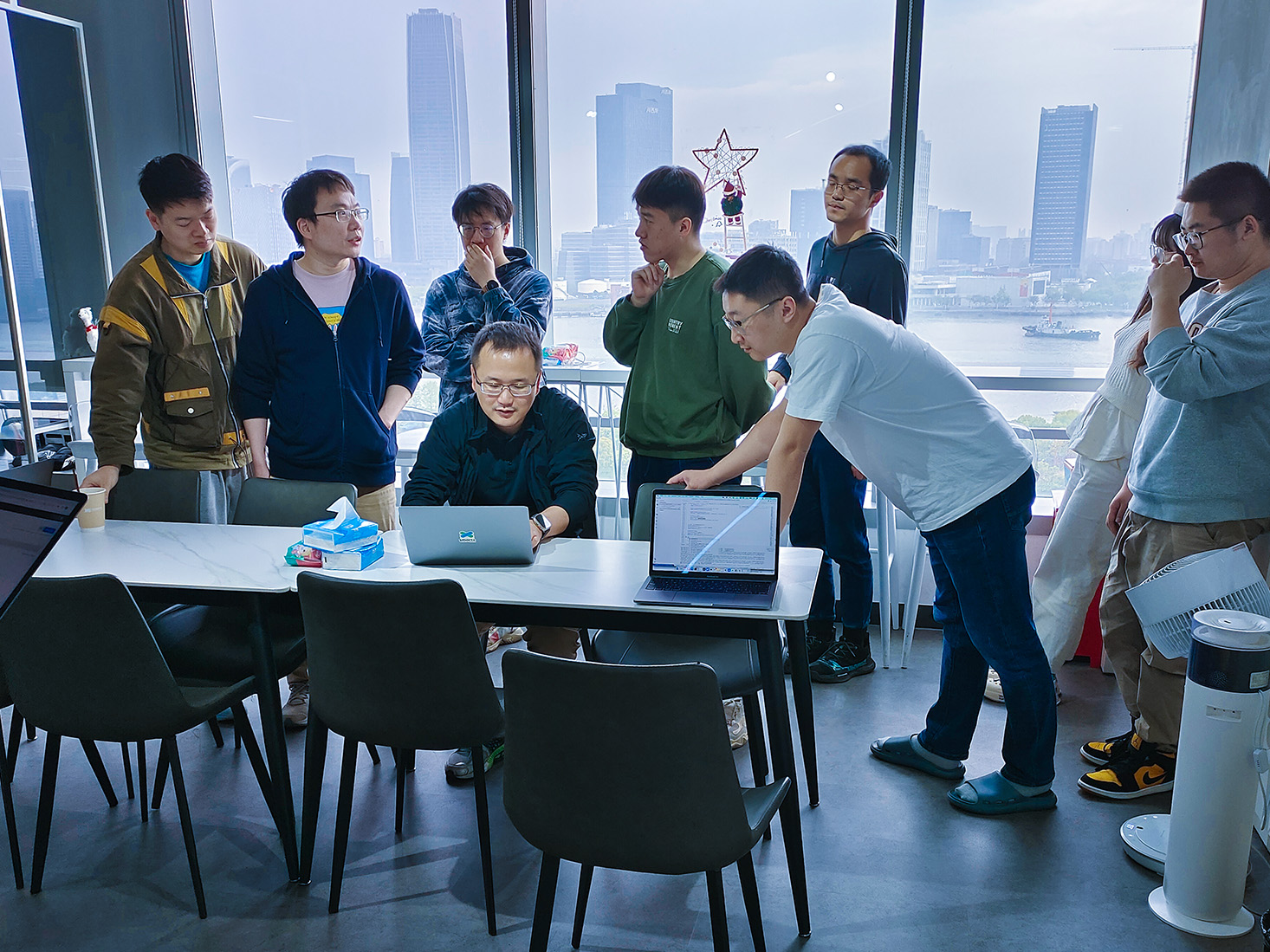 上海办公室里围在一起讨论工作的工程师。